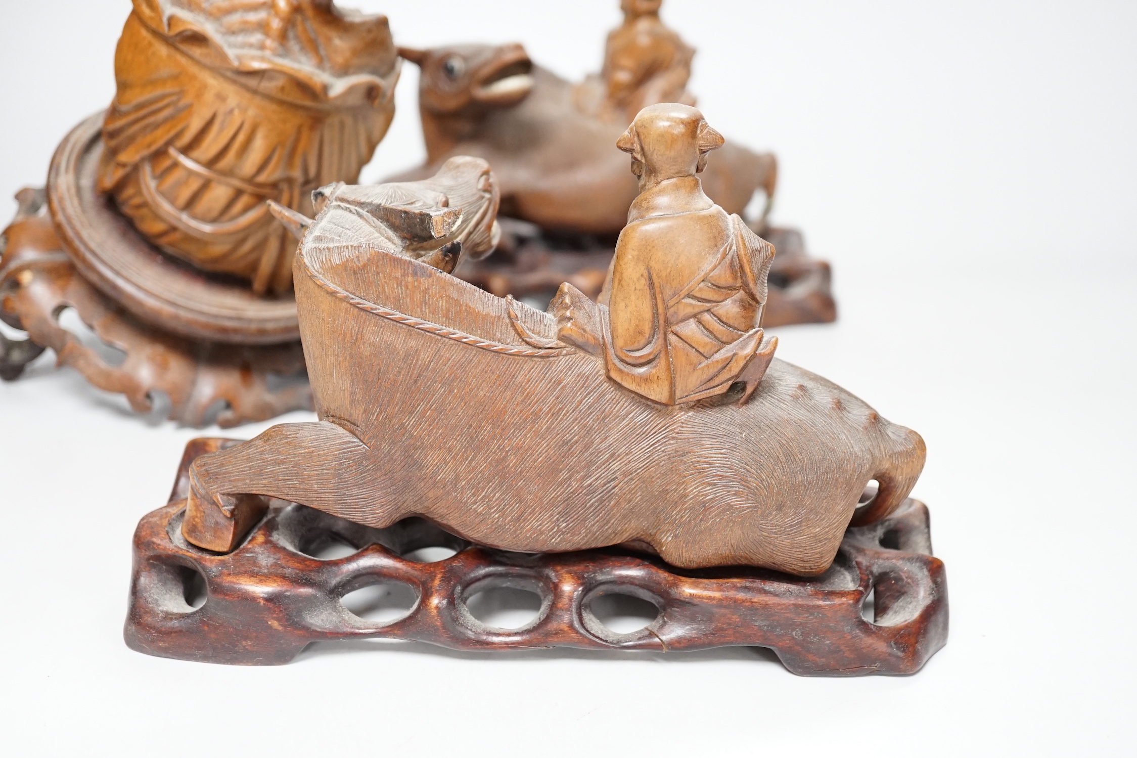 A pair of Chinese carved hardwood buffalo carvings, and a similar figure of a luohan, latter 24cm - damaged